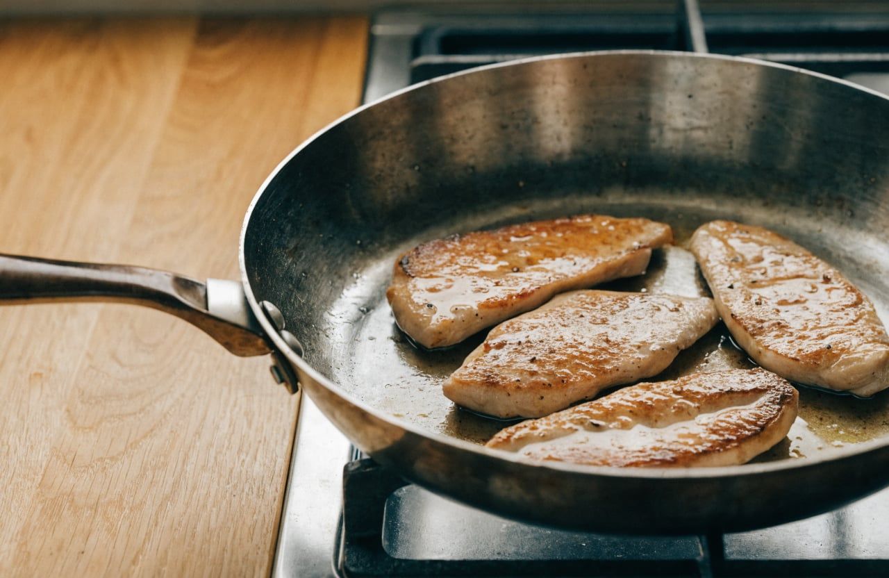Thin chicken cutlets seared deep golden in a large skillet