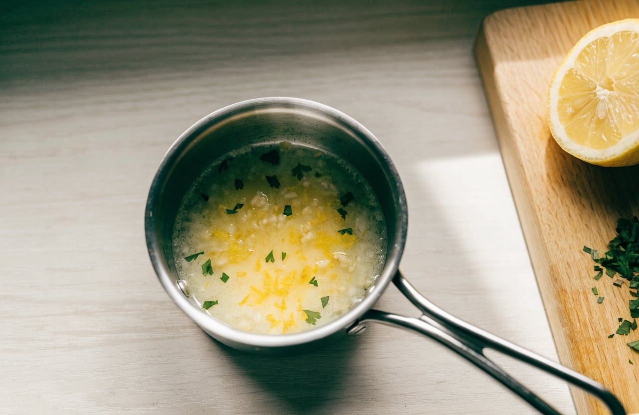 Small saucepan of melted butter with pale minced garlic, lemon zest and chopped parsley