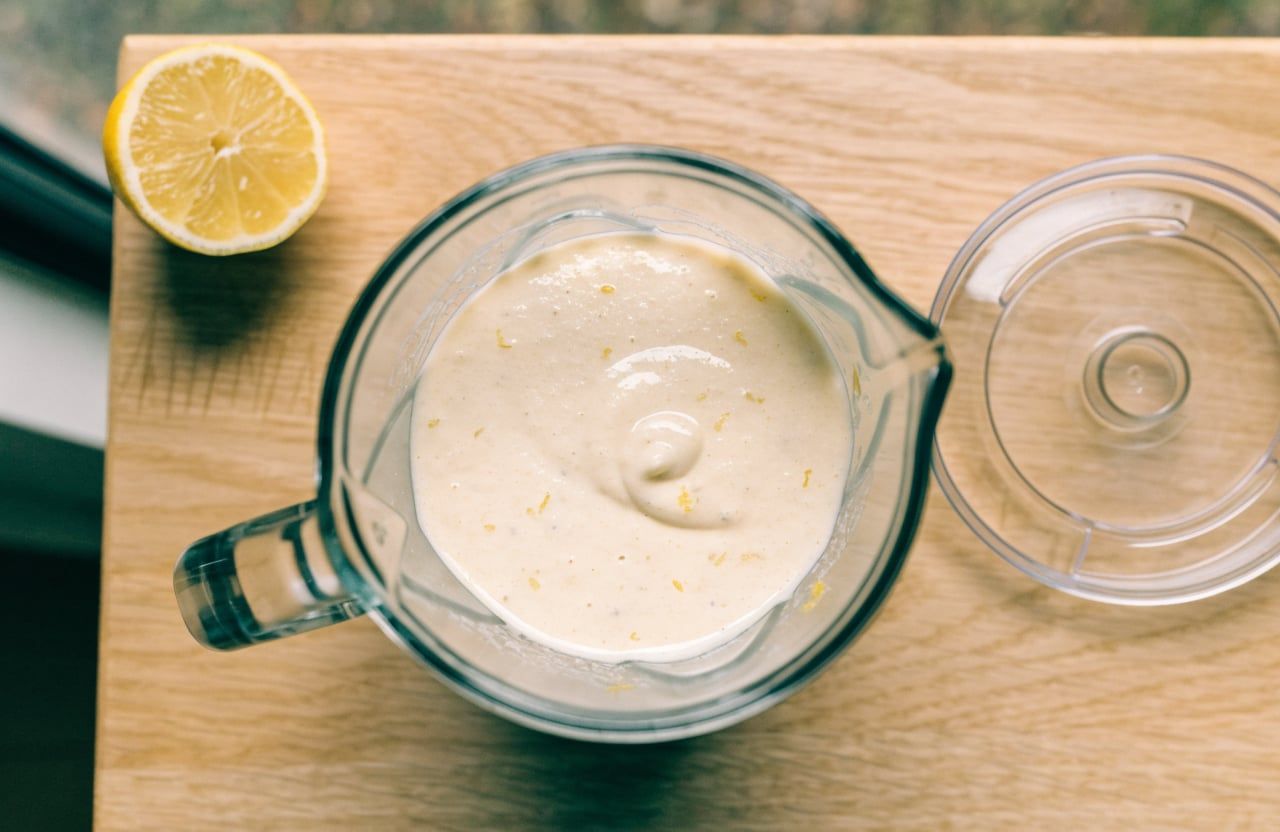 Blender jar full of smooth pale-ivory cottage cheese and egg batter with no curds