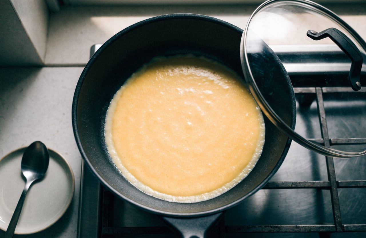 Thin round of pale-yellow batter spread about 9 inches wide in a nonstick skillet