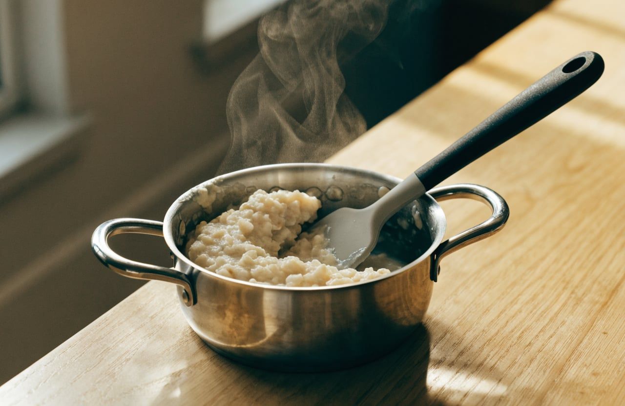 Thick, fluffy, opaque oatmeal pulling away from the saucepan in a soft mass