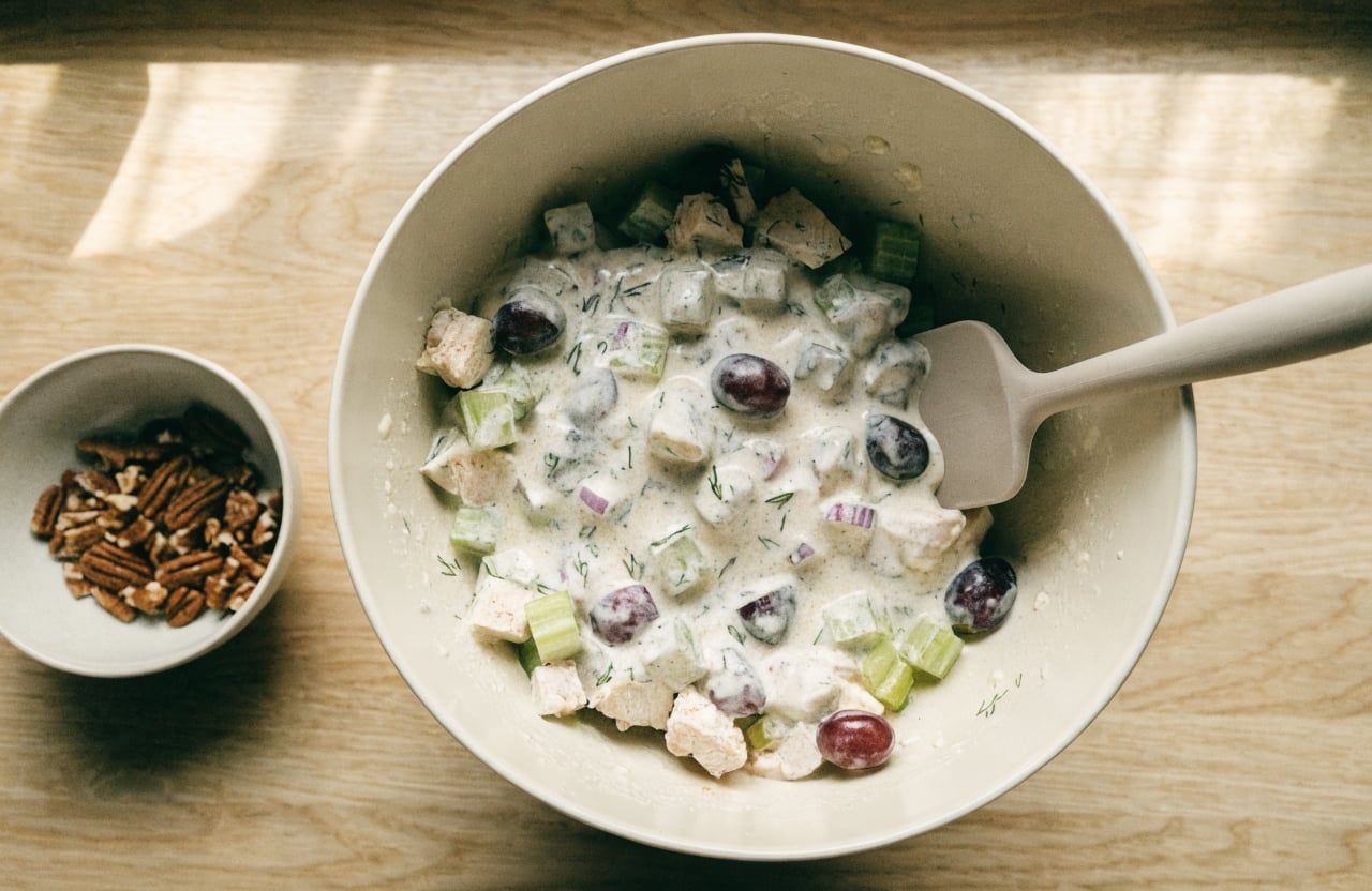 Diced chicken, grapes, celery and red onion folded into creamy yogurt dressing in a bowl